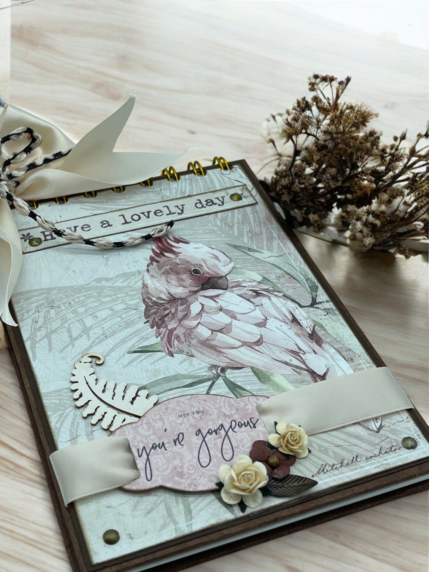 A6 cockatoo notebook with Nepalese paper, ribbons, and paper flowers—customisable handmade spiral journal with 40 white pages and shabby chic charm.