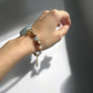 An aquamarine and agate crystal bracelet with gold plating on a hand