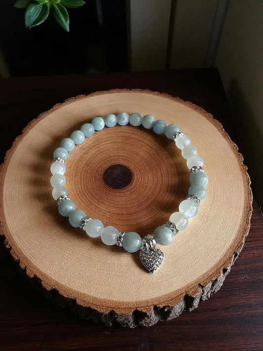 Aquamarine and Moonstone bracelet with rhinestone heart charm on a wooden slab