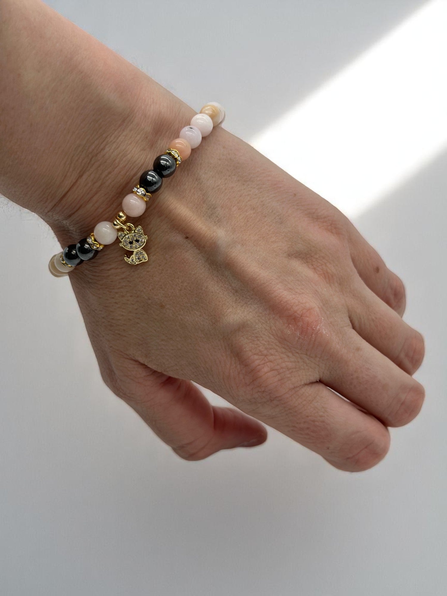 Beaded gemstone bracelet featuring pink opal and hematite stones
