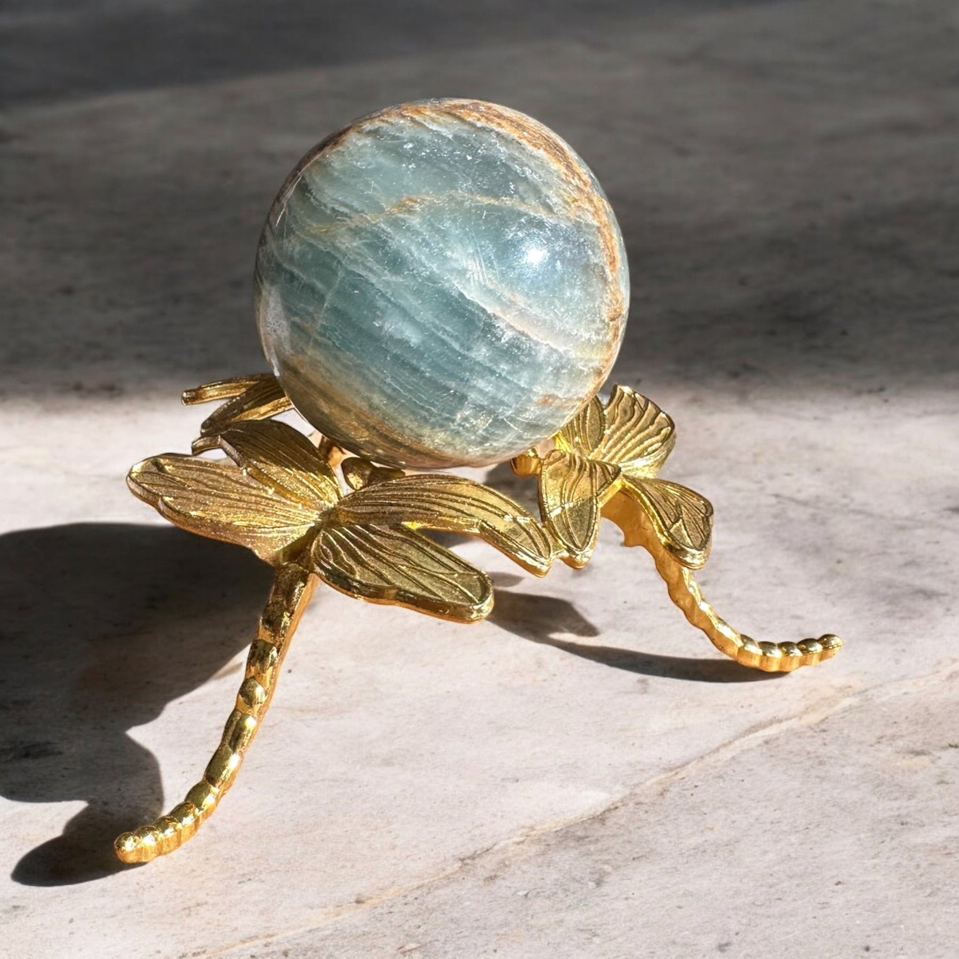 Blue onyx crystal sphere on a golden stand