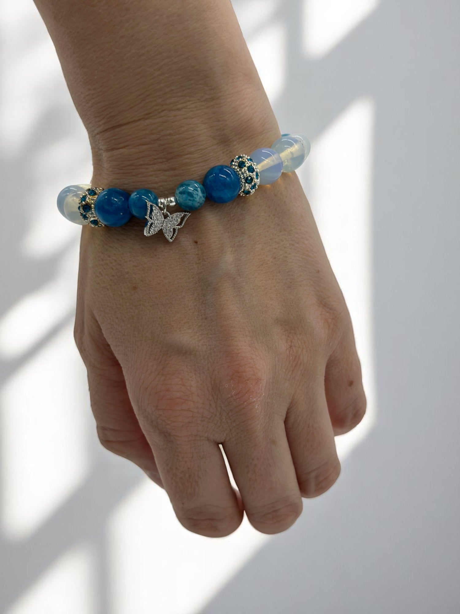 Butterfly charm bracelet with glowing opalite and vibrant blue apatite