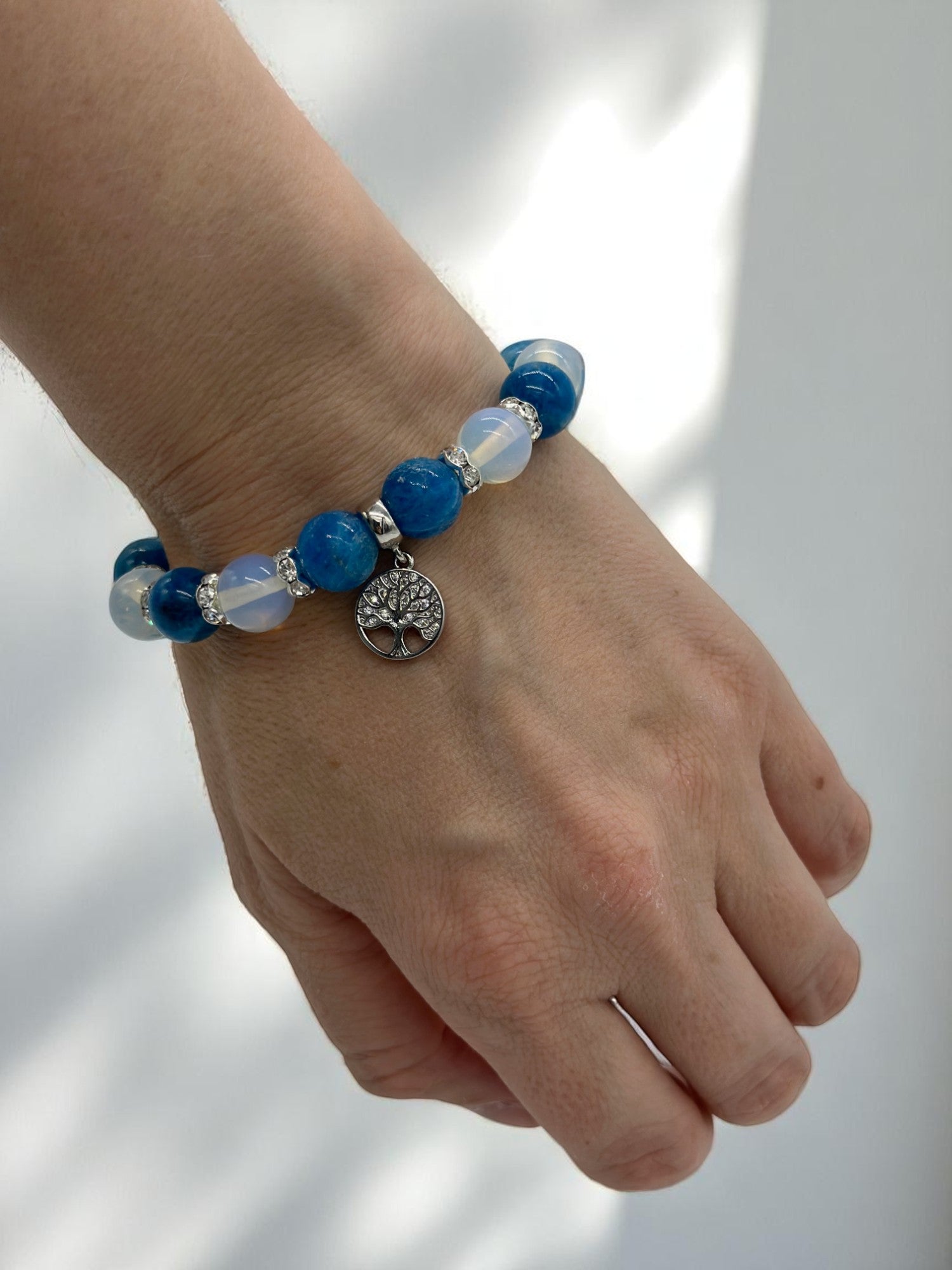 Close-up of crystal bracelet with glowing opalite and motivational apatite