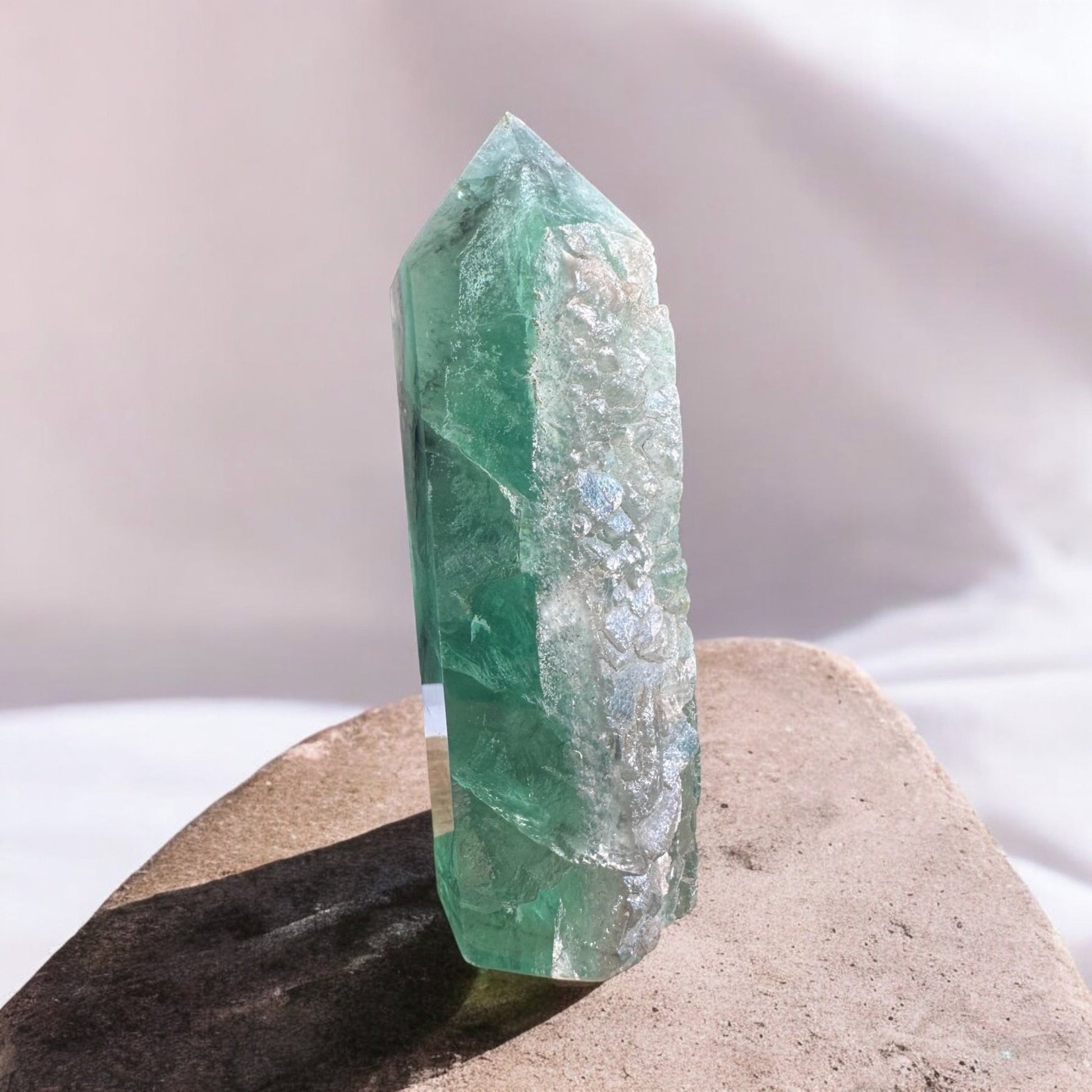 Green fluorite crystal tower with rough side