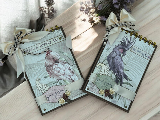Handmade A6 cockatoo spiral notebook with 40 white pages, golden spiral top binding and removable bow—customisable shabby chic journal in purple and pink.