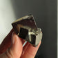 Holding a tiny pyrite cube in my hand