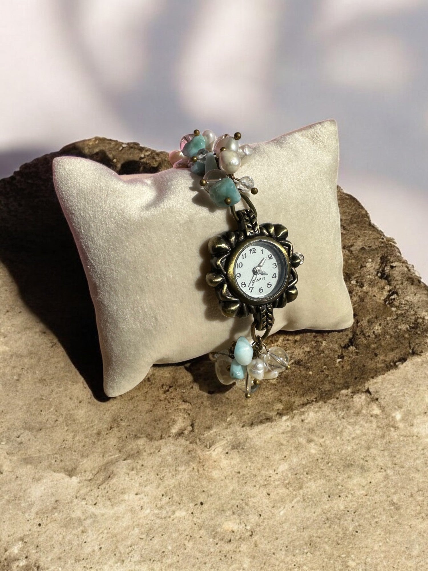 Larimar, Pearl, and Clear Quartz Custom Watch on a pillow