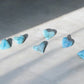 Larimar stone crystal hearts on concrete