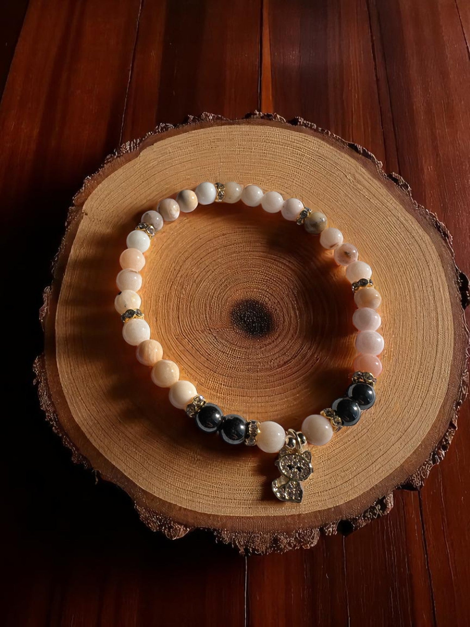 Pink Opal and Hematite bracelet with cute cat charm on a white background