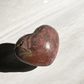 Polished Rhodochrosite heart showcasing natural pink banding