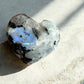 Rainbow moonstone crystal heart on concrete