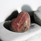 Rhodochrosite crystal heart highlighting its soft pink tones