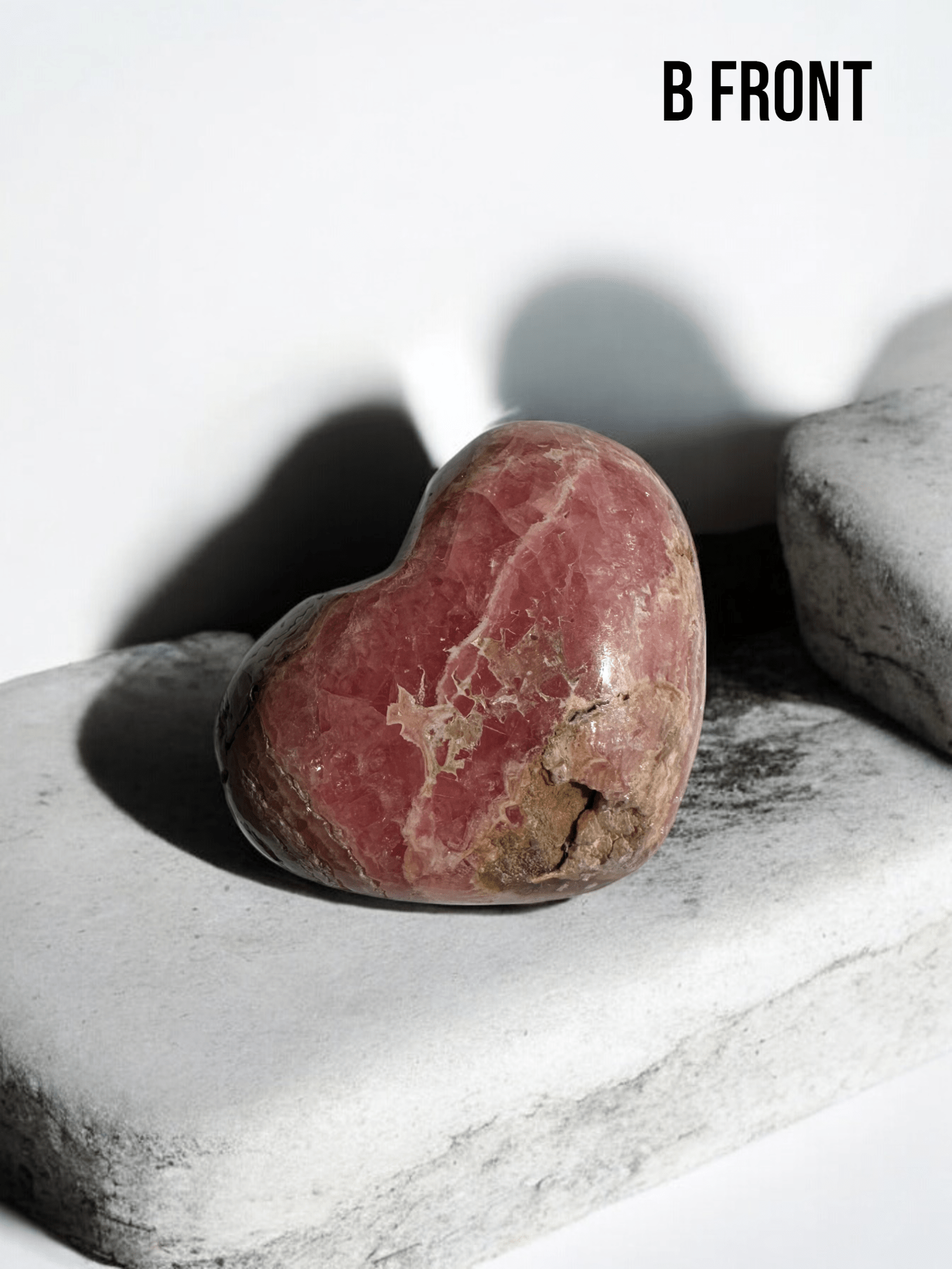 Rhodochrosite crystal heart highlighting its soft pink tones