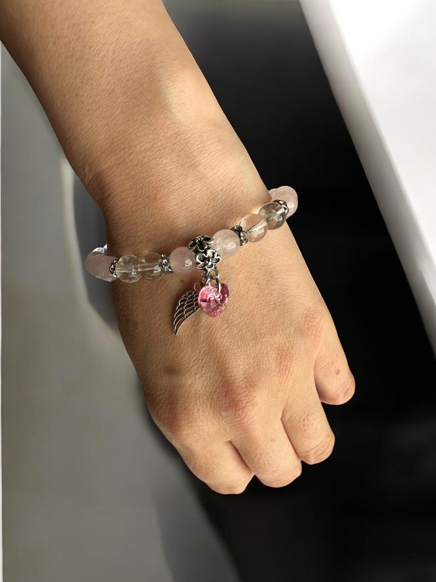 Wearing a Rose Quartz and Clear Quartz Swarovski Heart with wing Crystal Bracelet