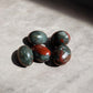 african bloodstone tumbled crystals on concrete