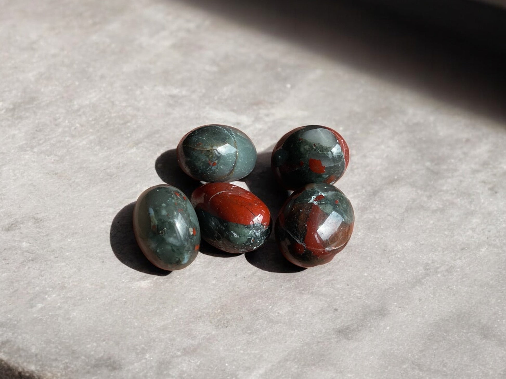 african bloodstone tumbled crystals on concrete