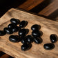 Black obsidian tumbled crystals on a slab