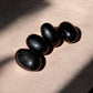 Black obsidian tumbled crystals on concrete