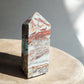 Crazy lace agate crystal obelisk on a concrete slab