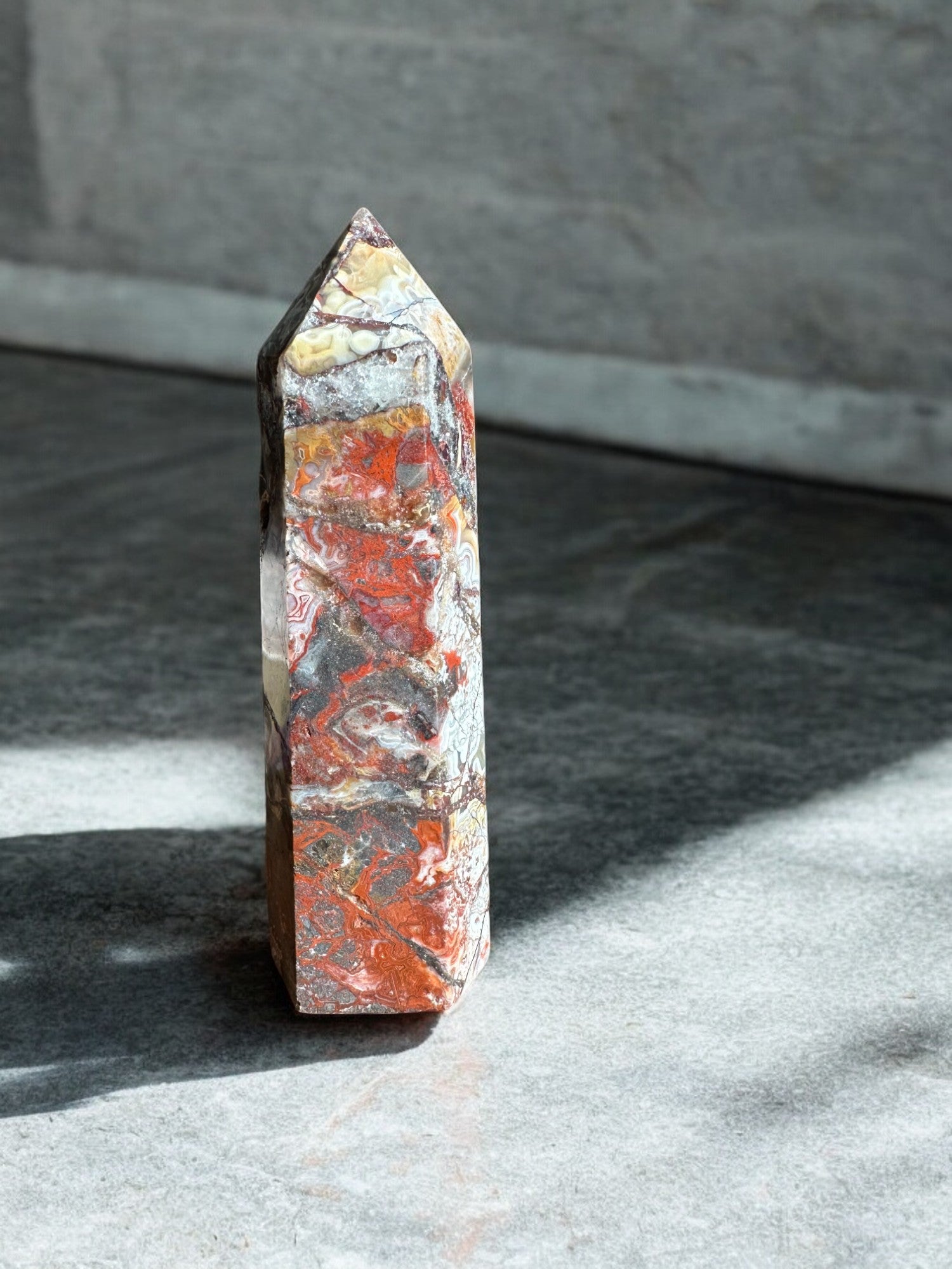 Crazy lace agate crystal tower option ML4 on a concrete with lots of iron