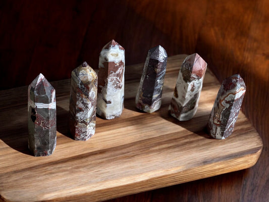 Crazy lace agate crystal towers on a wooden slab