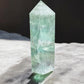 Green fluorite crystal tower on a concrete slab back view