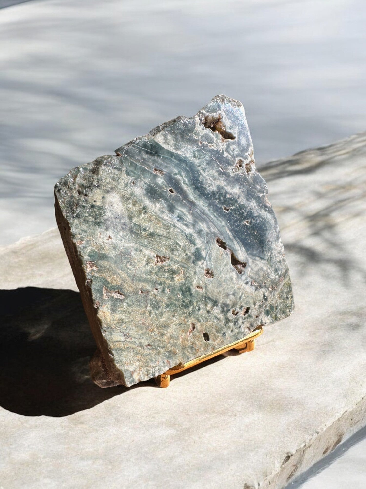 Ocean jasper crystal slab on a stand with green