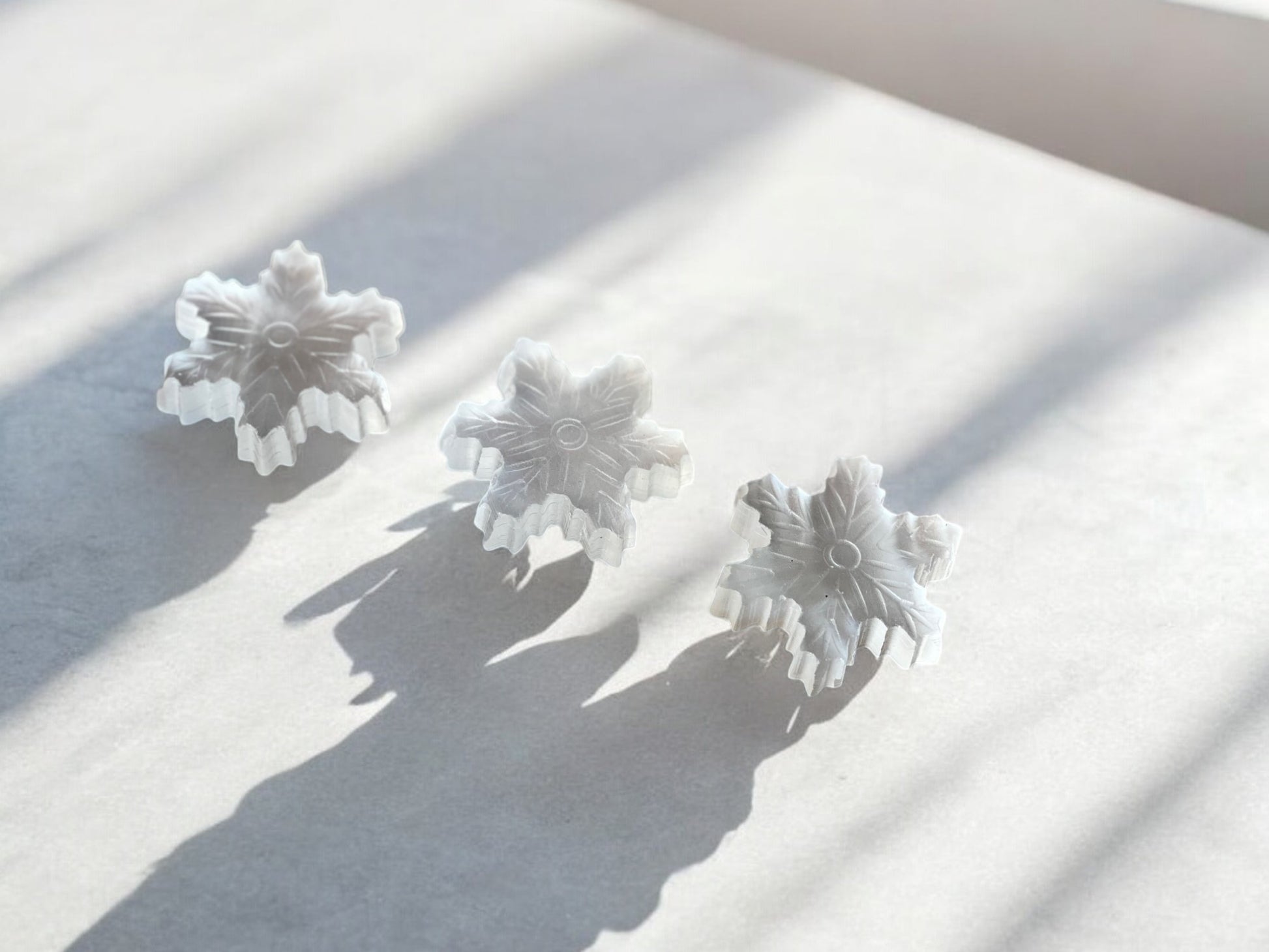 selenite snowflake crystal figurines on concrete