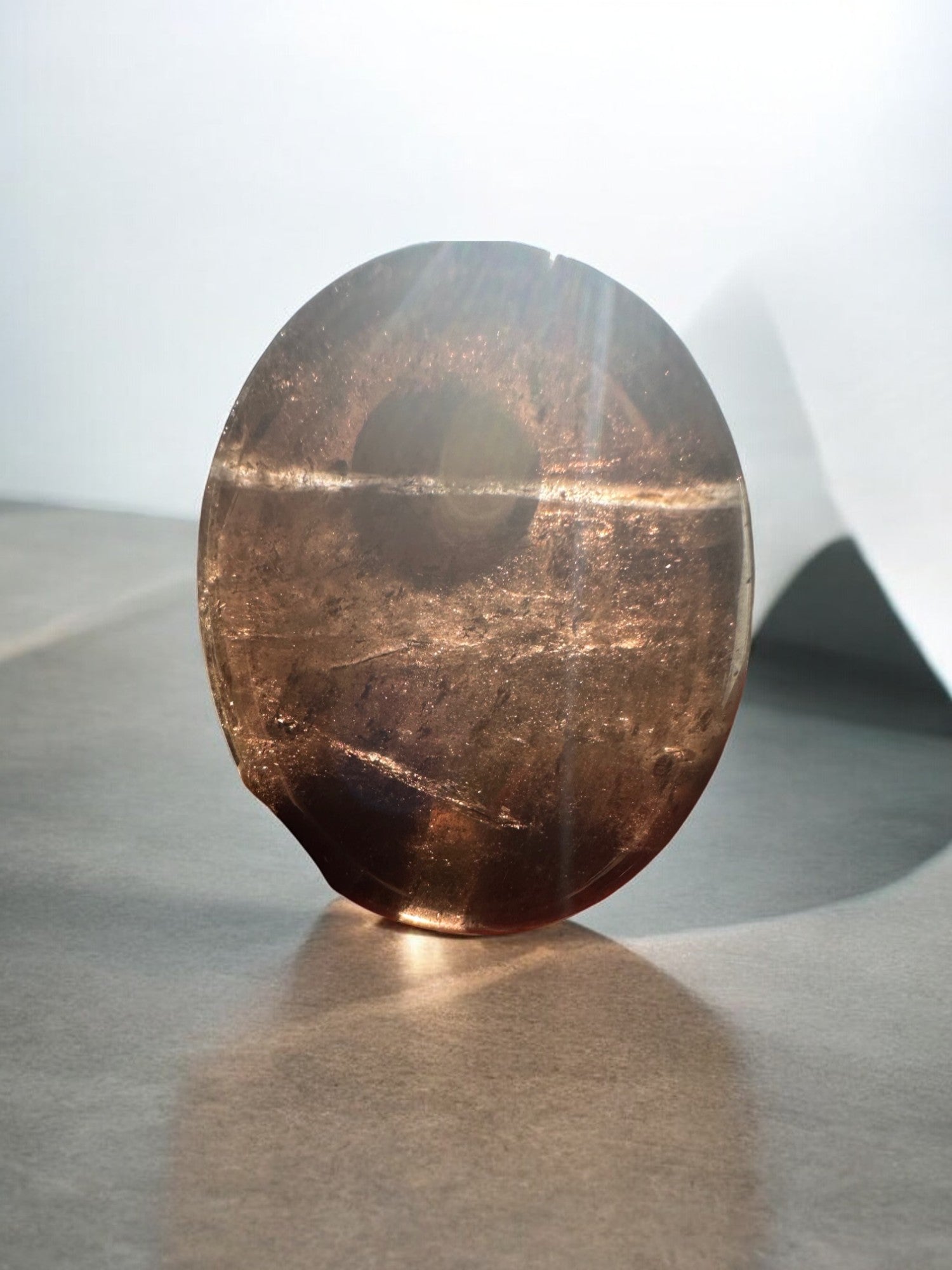 Smoky quartz worry stone in sunlight
